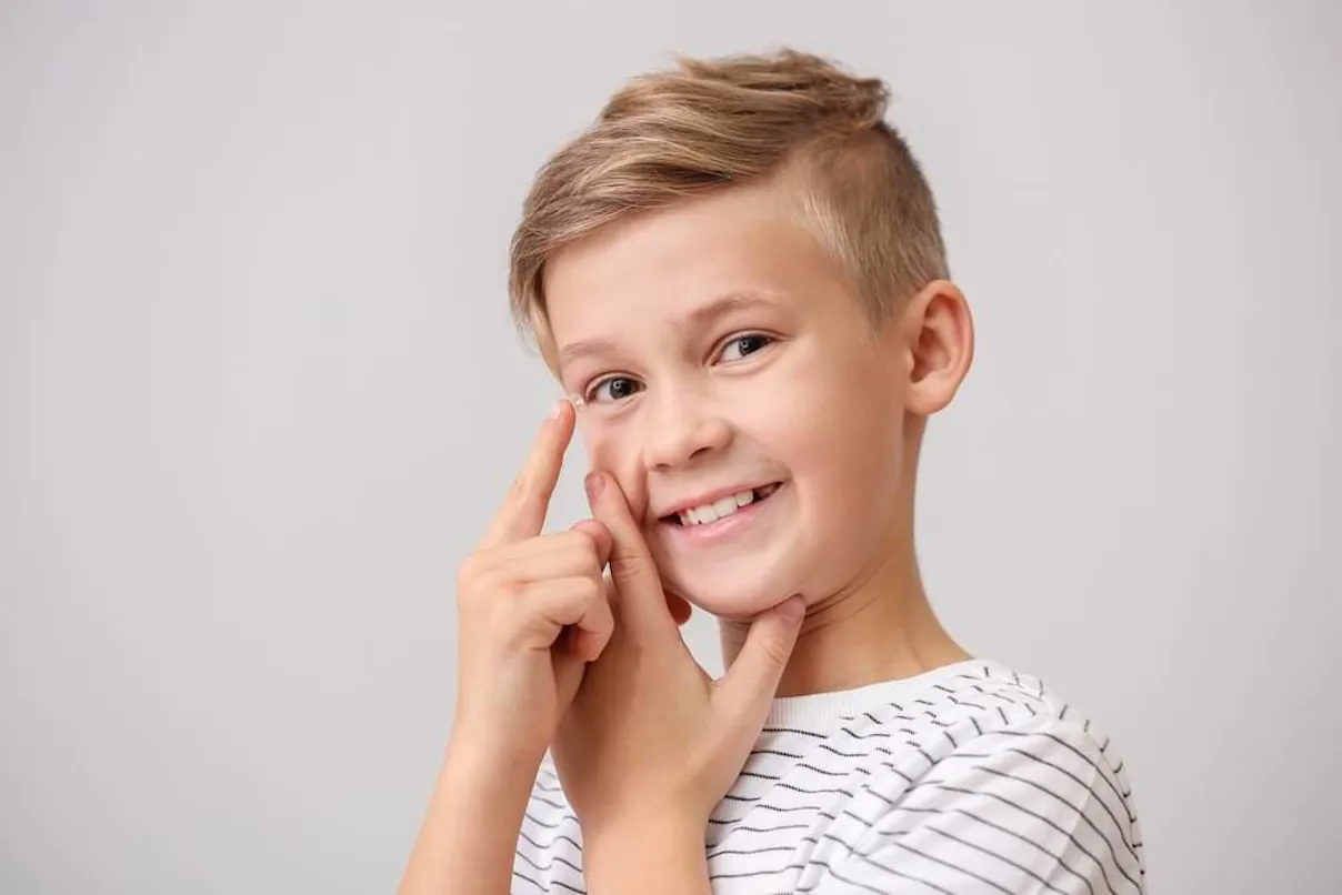 Un grazioso bambino che utilizza lenti a contatto misight