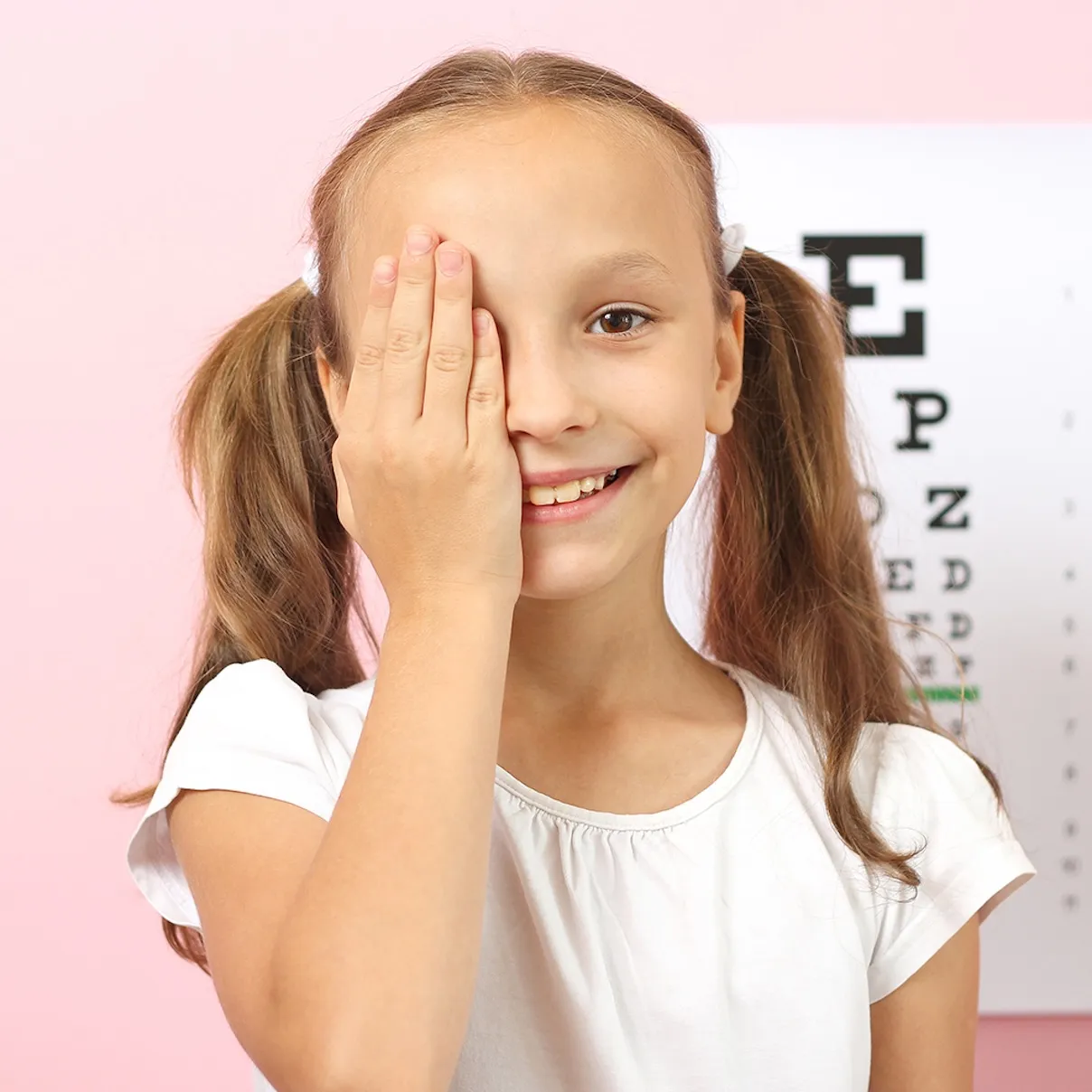 Una graziosa bambina controlla la vista con un oculista. Esame della vista.