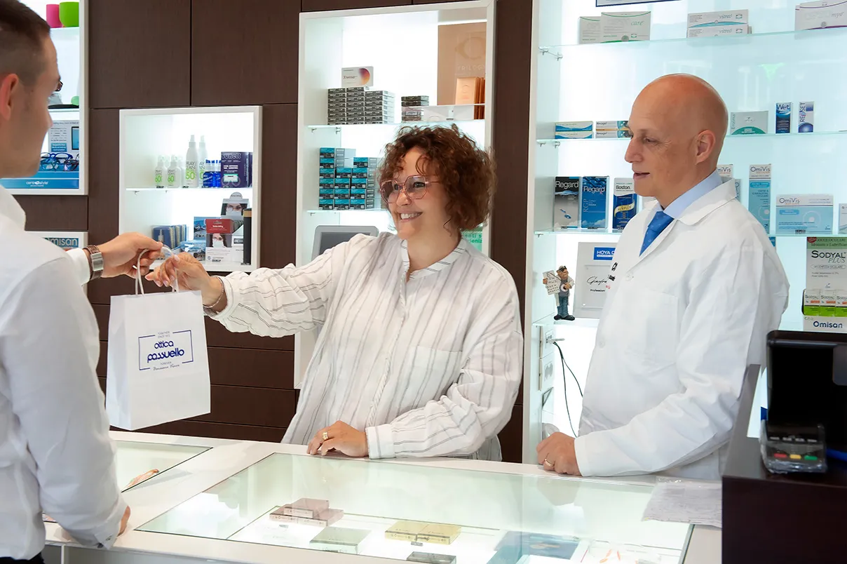 Angela Passuello consegna una borsa a un cliente all’interno dell’ottica